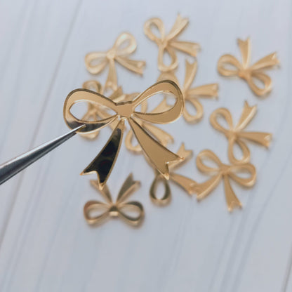 Apliqué acrílico lazo dorado - 100 un