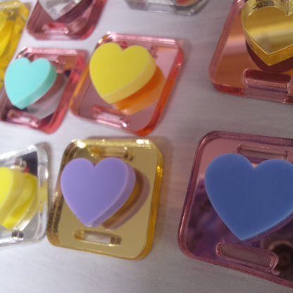 20un Dije acrílico pasa elástico corazón mix colores